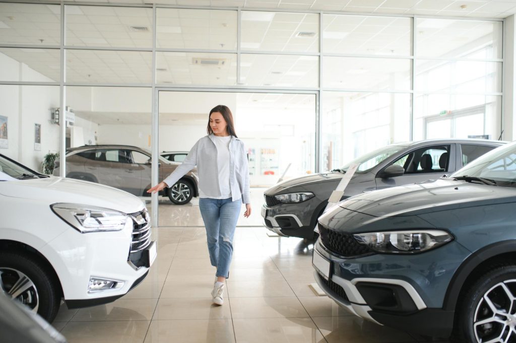 Young business woman choosing a car in a car salon